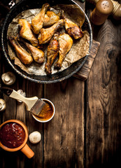 Fried chicken legs with tomato sauce.