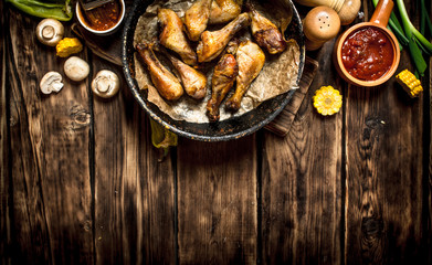 Fried chicken legs with tomato sauce.