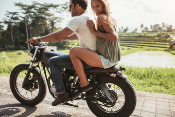 Obraz na płótnie Canvas Young couple riding on a motorbike