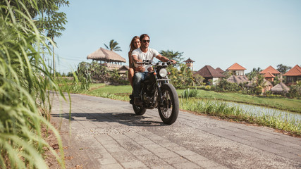 Fototapeta premium Young couple riding motorcycle on rural road