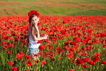 Obraz na płótnie Canvas Girl in the poppy field