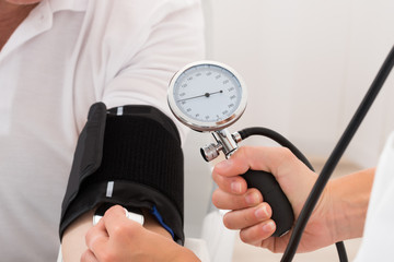 Doctor Checking Blood Pressure Of Patient