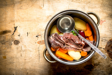 big pot of soup with beef and fresh vegetables.