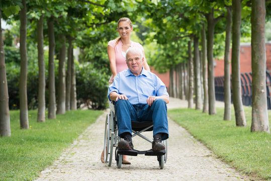 Woman With Her Old Senior Father On Wheelchair