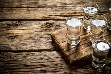 Foto op Plexiglas Glasses with vodka on the old Board. © Artem Shadrin