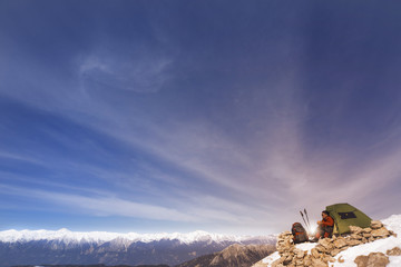 Winter camping in the mountains with a backpack and tent.