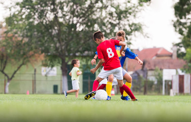 Boys playing football soccer game on sports field