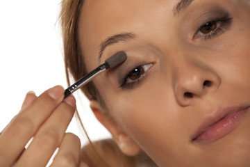 Fototapeta premium young beautiful woman applied eye shadow with applicator..