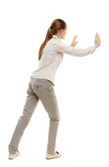 back view of woman pushes wall. Isolated over white background. Skinny girl in white denim suit...