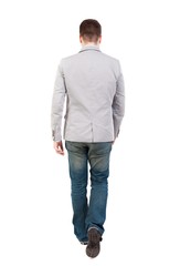 Back view of walking businessman. man in a gray jacket leaves the frame.