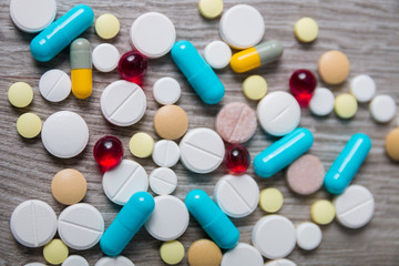lot of colorful medication and pills from above on grey wooden background. Copy space. Top view,...