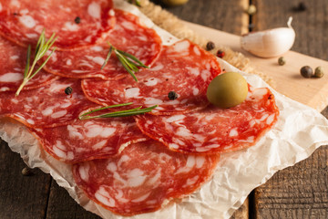 Chorizo sausage and salami, thin cut. spanish salami on the wood background with spices, paprika, pepper. Spicy food. Chili.