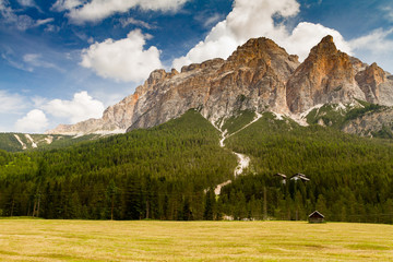 Dolomites Italy, barn in a grazing under a mountain in a sunny d