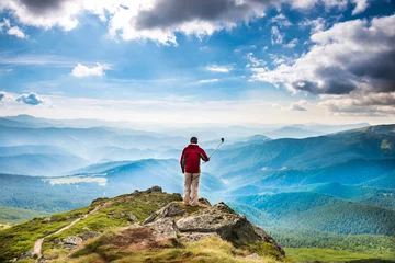 Fototapeten Junger Mann am Berg macht Selfie © Pavlo Vakhrushev