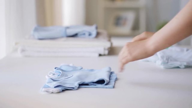 woman hands folding baby boys clothes at home 22