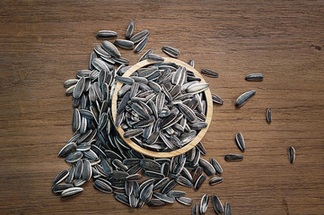 sunflowers seeds in wood bowls on wood background