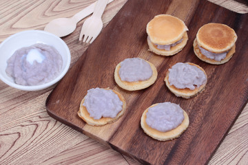 Mini pancake topped stirred taro on wood. 