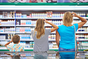 Family chooses dairy products in shop - Powered by Adobe