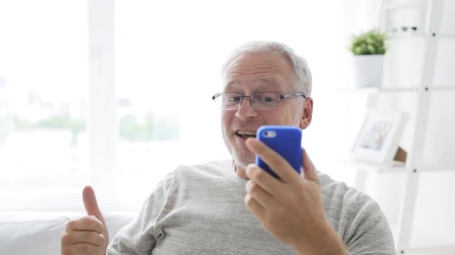 senior man having video call on smartphone at home 124