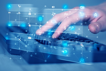 Hand pressing keyboard with high tech media icons
