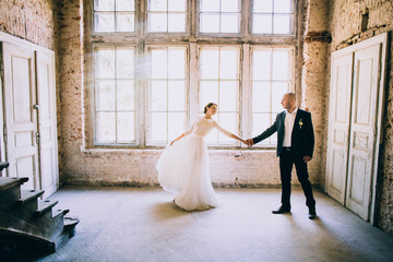 happy newly married couple posing by the window. Loft