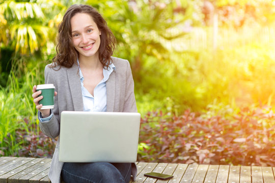 Young Attractive Business Woman Working At The Park During A Pau