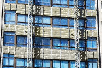 workers installing aluminium composite panels to repair , restore , the facade of building