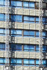 workers installing aluminium composite panels to repair , restore , the facade of building
