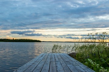 Beautiful tranquil summer sunset on the Onega lake, Karelia, Russia. View from wooden pier
