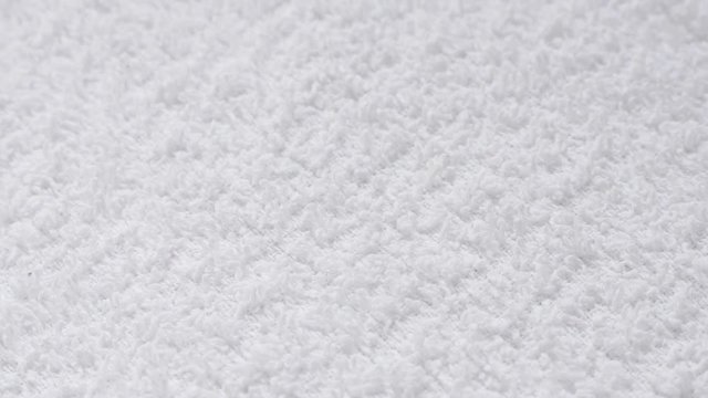 Absorbent fabric of white towel surface close-up slow tilt 4K 2160p 30fps UHD footage - Fine texture of bath towel cloth background 4K 3840X2160 UltraHD tilting video 