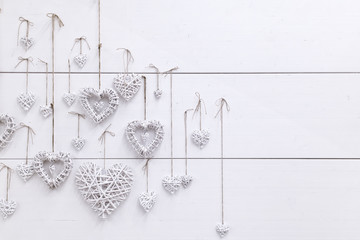 White hearts ,handmade, hanging on a white wall.