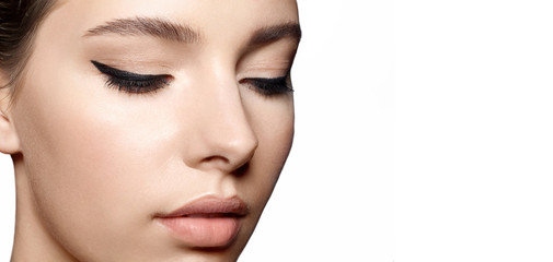Naklejka premium Woman with clean skin with natural make-up and with black arrows on the eyes close up
