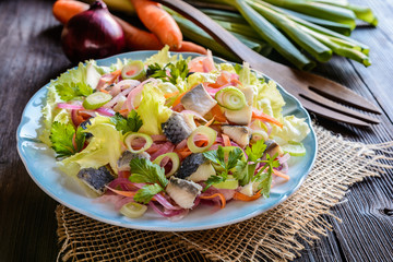 Fish salad with pickled herring, lettuce, roasted onion and parsley