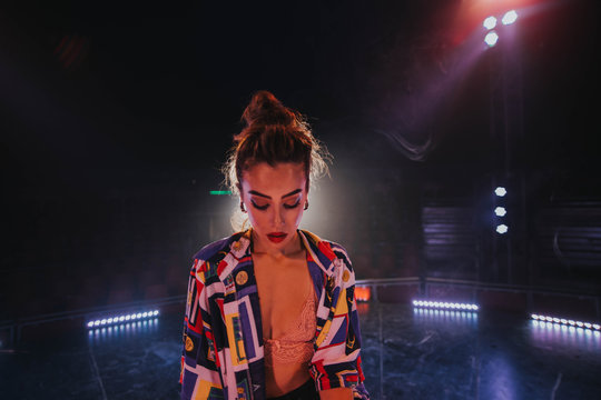 Woman standing on stage with illuminated spotlights