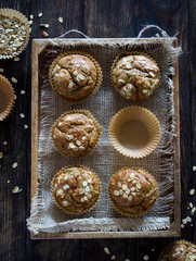 Healthy wholewheat and oatmeal muffins, served in a box, vertical shot, overhead view