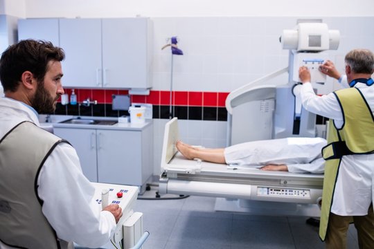 Doctor using x-ray machine to examine patient