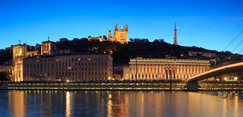 Night view over the Saone river to the courthouse and Fourviere cathedral in Lyon city.