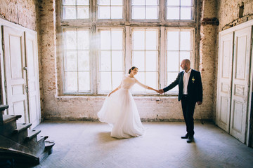 happy newly married couple posing by the window. Loft