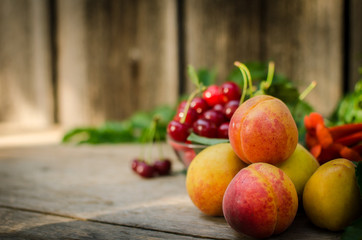Still life of summer fruits. orange peaches, red cherries and gr
