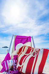 beach with deck chair, towel, bag, hat