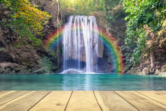 Waterfall, green forest in Erawan National Park in Thailand montage with wooden floor. Landscape with water flow, tree, river, stream and rock at outdoor. Beautiful scenery of nature for vacation. © DifferR