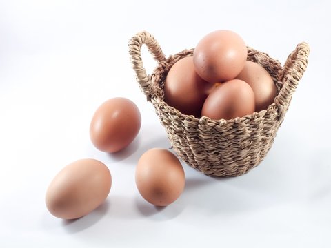 Hen egg in the basket on white background.