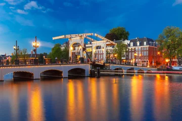 Poster Magere Brug, Magere brug, met nachtverlichting over de rivier de Amstel in het centrum van Amsterdam, Holland, Nederland © Kavalenkava