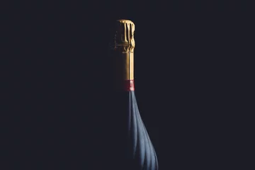 Zelfklevend Fotobehang Champagnefles op een zwarte achtergrond met ruimte voor tekst © ink drop