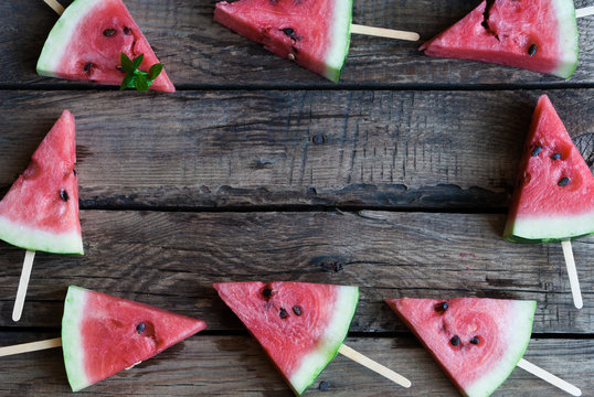 slices of watermelon on a dark wooden background
