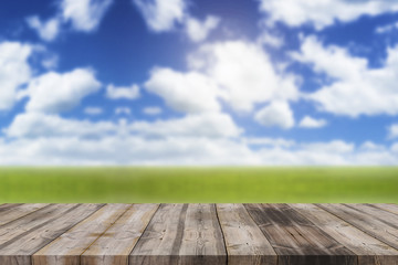 Wood top table on blur blue sky and green prairie background can