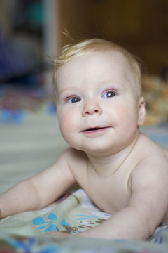 Cute baby lying on the bed, portrait, soft focus