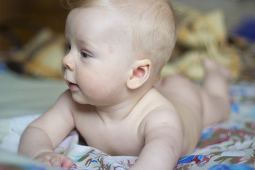 Cute baby lying on the bed, portrait, soft focus