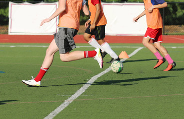 Fototapeta premium three soccer players bring the ball down the field at practice