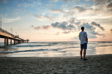 Fototapeta premium Ragazzo al tramonto in spiaggia